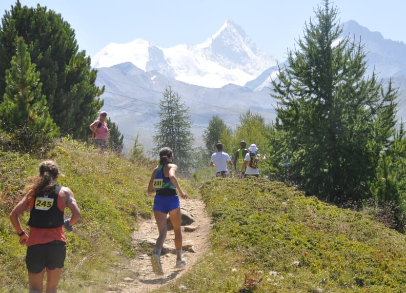 Coureurs sur les sentiers de Sierre-Zinal face aux montagnes