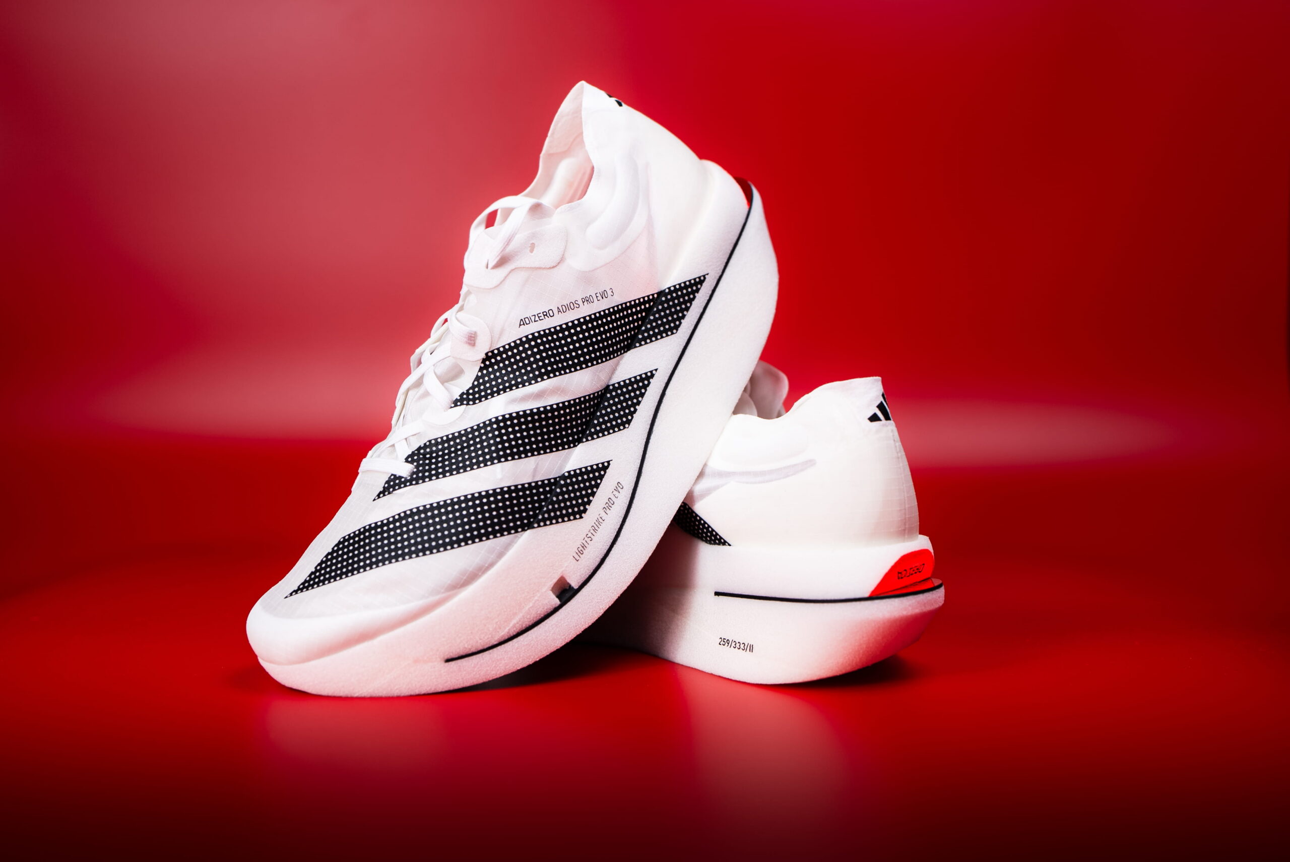 Adidas Adizero Adios Pro Evo 3 sur fond rouge, running